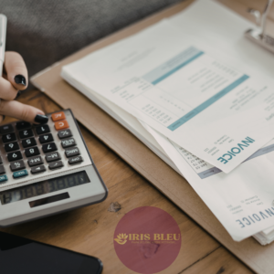 Main d'une personne utilisant une calculatrice à côté de factures posées sur un bureau, avec le logo Iris Bleu en surimpression.